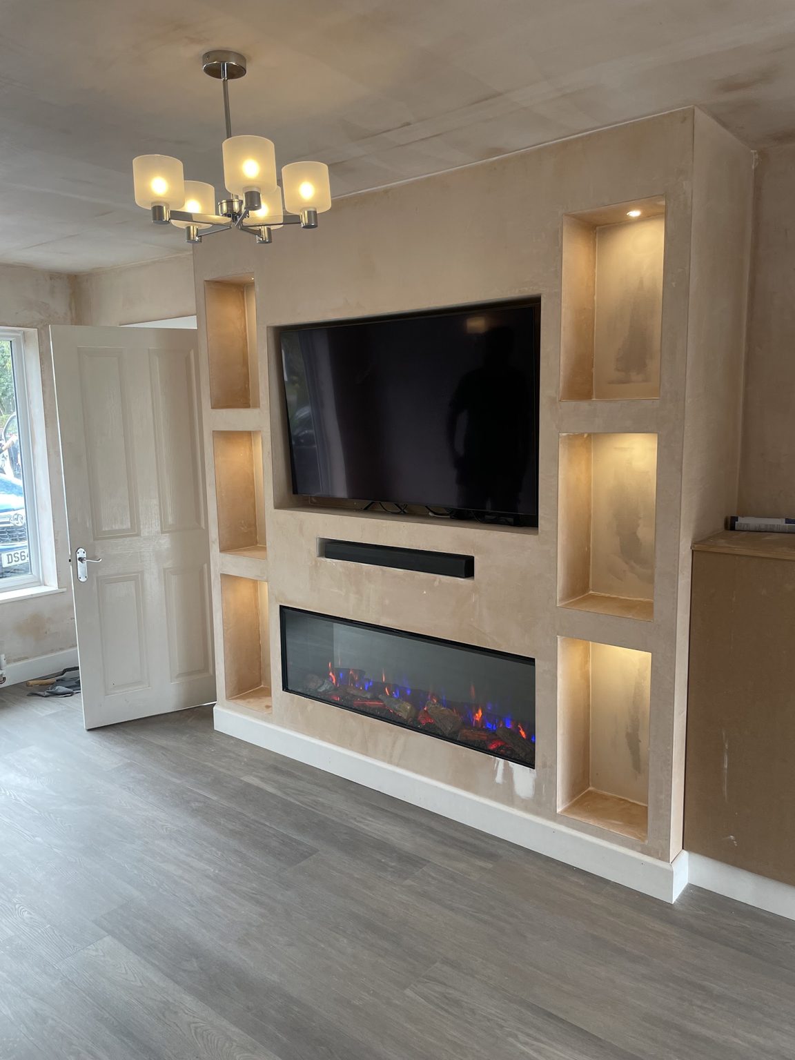Media wall with lit alcoves and a pendant light