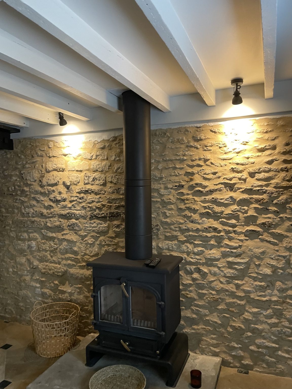Beamed room with spotlights over a log burner