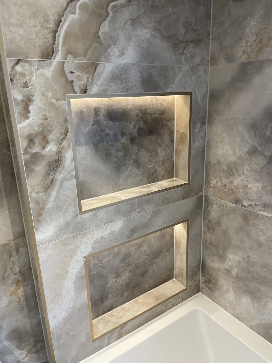 Bathroom with lit recesses above the bath